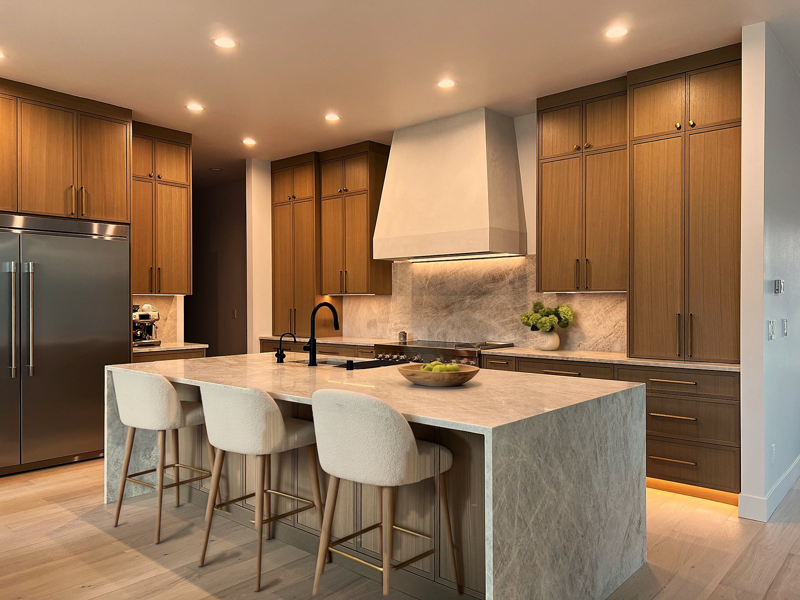 Custom kitchen with oak cabinetry, quartzite waterfall island, plaster hood and counter stools